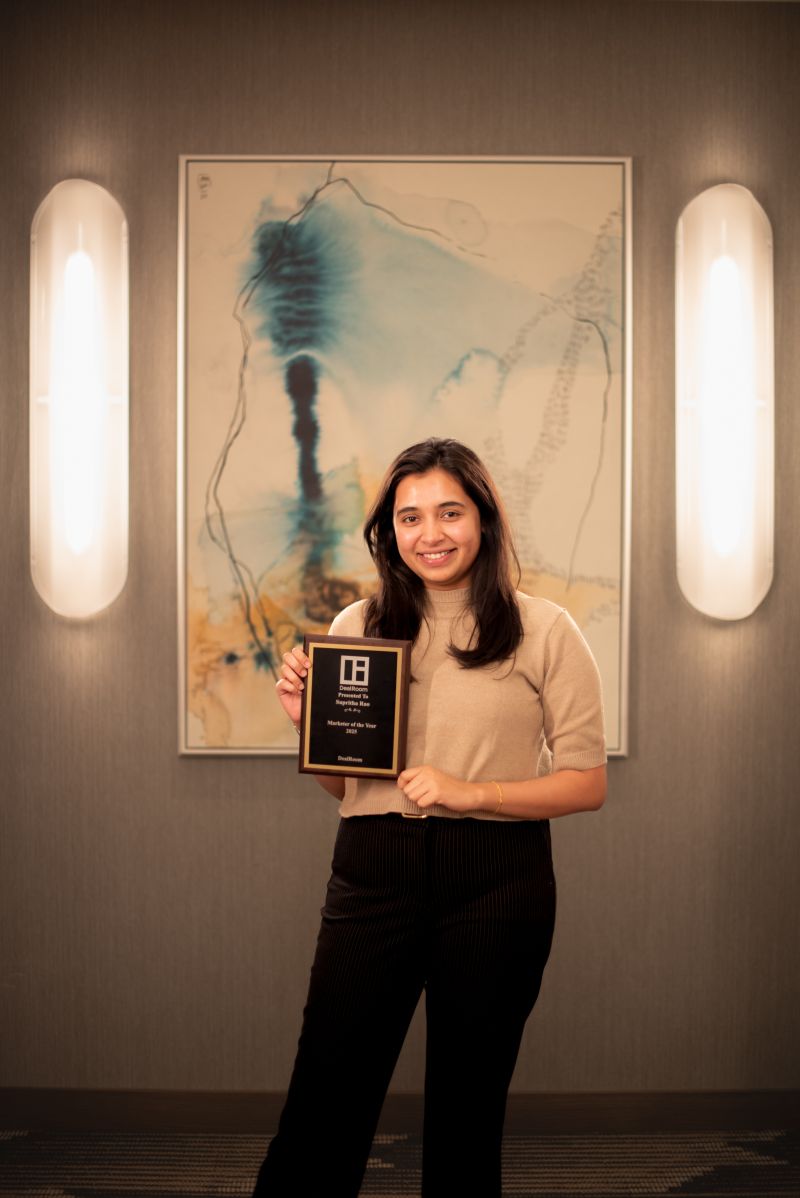 Supritha holding the DealRoom Marketer of the Year 2025 award
