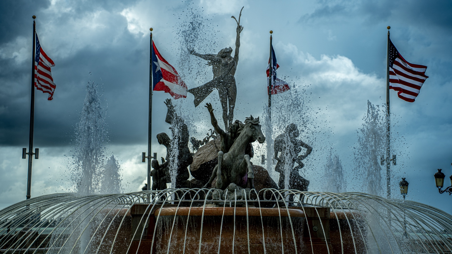 The Raíces Fountain with Puerto Rican and American flags in the wind